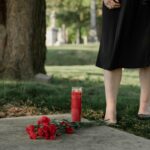 Slika groba s svečo in rožami